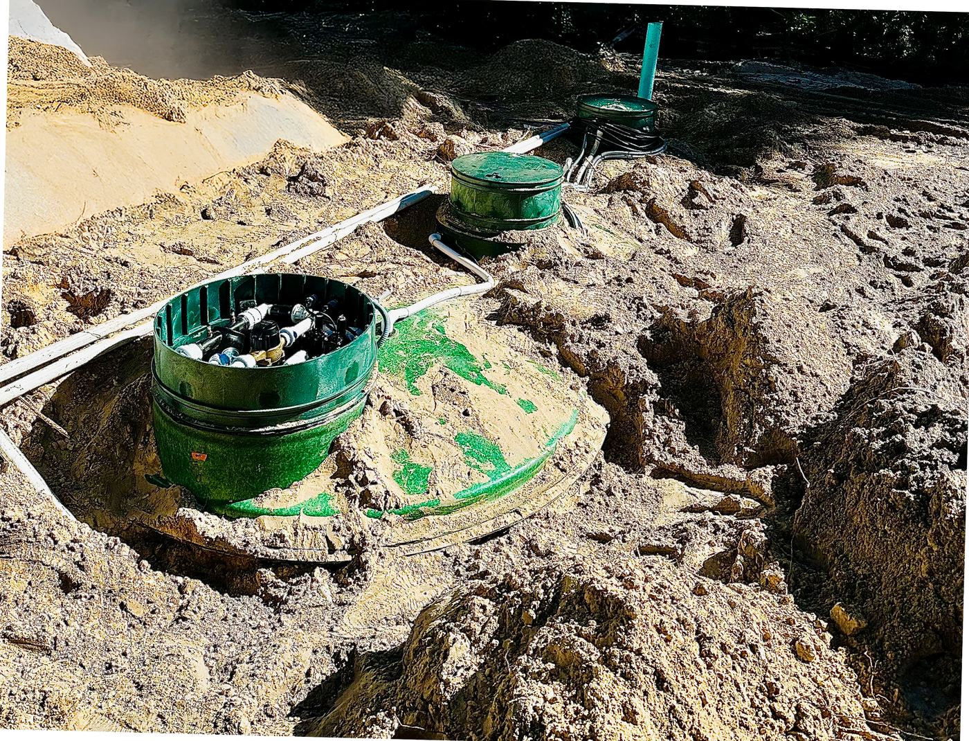 Drip system components set in the excavation with basins, piping and conduit run